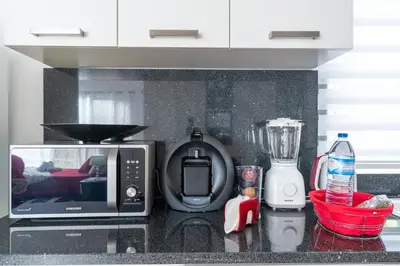 a kitchen counter with a microwave and a blender at Casa Annie in Arco da Calheta