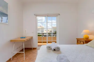 a bedroom with a bed and a desk and a window at Spacious Villa - Walk to Beach & City Center in Lagos