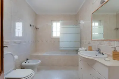 a bathroom with a toilet and a sink and a tub at Spacious Villa - Walk to Beach & City Center in Lagos