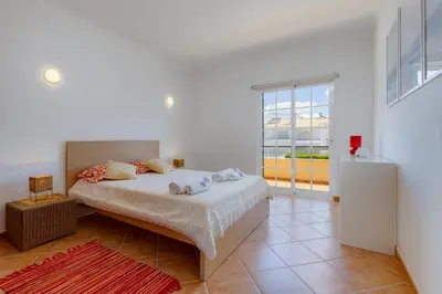 a bedroom with a bed and a large window at Spacious Villa - Walk to Beach & City Center in Lagos