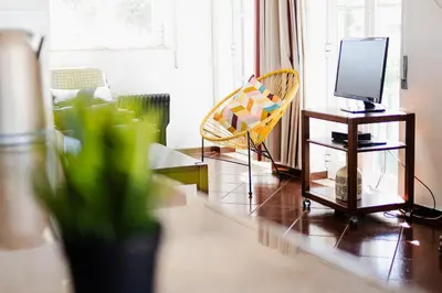 a living room with a tv and a chair at Sunny House in Sagres