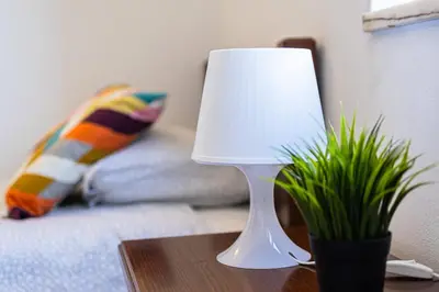 a white lamp on a table next to a couch at Sunny House in Sagres