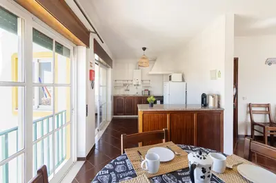 a kitchen and dining room with a table and chairs at Sunny House in Sagres