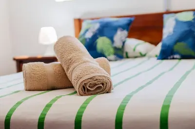 a couple of rolled up towels on a bed at Sunny House in Sagres