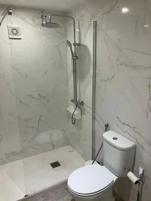 a white bathroom with a toilet and a shower at Vista Montanha Funchal in Funchal