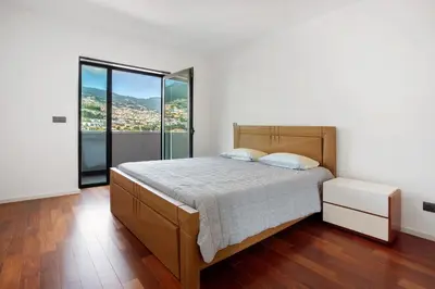 a bedroom with a bed and a large window at Macedo Penthouse in Funchal