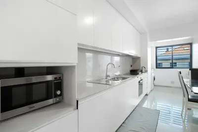 a white kitchen with a sink and a microwave at Macedo Penthouse in Funchal