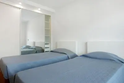 a bedroom with two beds and a mirror at Macedo Penthouse in Funchal