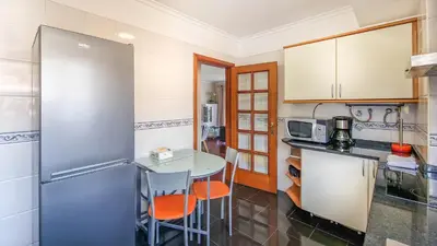 a kitchen with a table and a refrigerator at Madeira Residence in Funchal