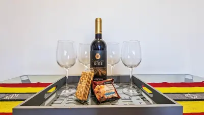 a tray with a bottle of wine and three wine glasses at Madeira Residence in Funchal