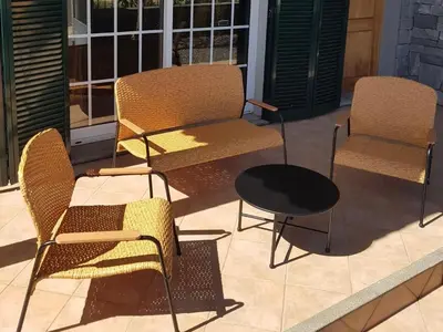 three chairs and a table on a patio at Santo Refúgio in Porto Santo