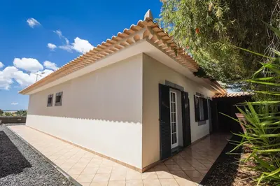 a bedroom with a bed and a wooden cabinet at Santo Refúgio in Porto Santo