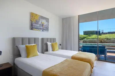 two beds in a hotel room with a large window at Cloud9 by LovelyStay in Funchal