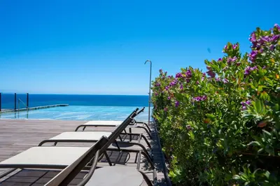 a row of chairs sitting on a boardwalk near the ocean at Cloud9 by LovelyStay in Funchal