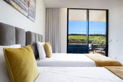 two beds in a hotel room with a view of the ocean at Cloud9 by LovelyStay in Funchal