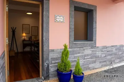 a table with an umbrella on a balcony with the ocean at Villa Izilda by ESCAPE to Madeira in Ponta do Sol