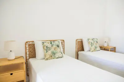 a bedroom with two beds and a night stand at Green House Beach Side Oasis in Vila Baleira