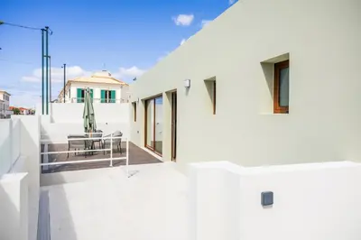 a view from the balcony of a white house at Green House Beach Side Oasis in Vila Baleira