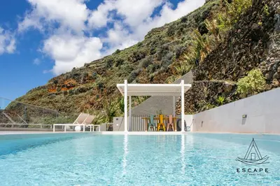 a resort pool with a mountain in the background at Villa Nicuma by ESCAPE to Madeira in Calheta