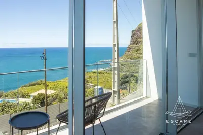 a kitchen with a sink and a living room at Villa Nicuma by ESCAPE to Madeira in Calheta