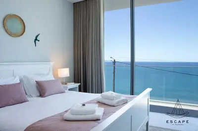a bedroom with a bed with a large window at Villa Nicuma by ESCAPE to Madeira in Calheta
