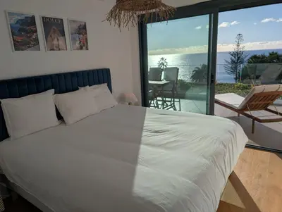 a bedroom with a large white bed and a balcony at Breathtaking Oceanfront Living, Sunset Facing 3-Bedroom Flat in Acqua Residences in Funchal