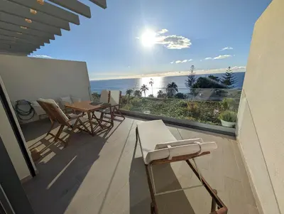 a balcony with tables and chairs and a view of the ocean at Breathtaking Oceanfront Living, Sunset Facing 3-Bedroom Flat in Acqua Residences in Funchal