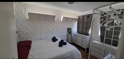 a white bedroom with a bed and a dresser at Great Stay 1 Bedroom Funchal Central Duplex Retreat in Funchal