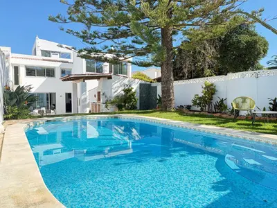a white house with a view of the ocean at Vila Golfinho, with heated pool, rooftop lounge and ocean views in Luz