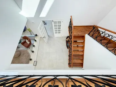 an empty room with a staircase with a skylight at Vila Golfinho, with heated pool, rooftop lounge and ocean views in Luz