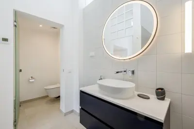 a bathroom with a sink and a mirror at Vila Golfinho, with heated pool, rooftop lounge and ocean views in Luz