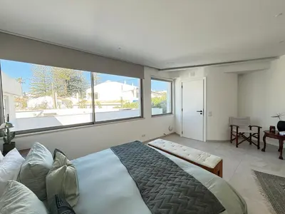 a white bathroom with two sinks and a tub at Vila Golfinho, with heated pool, rooftop lounge and ocean views in Luz
