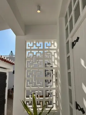 a hallway of a house with white walls and tile floors at Vila Golfinho, with heated pool, rooftop lounge and ocean views in Luz