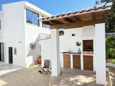 a large white house with a yard at Vila Golfinho, with heated pool, rooftop lounge and ocean views in Luz