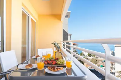 a table with a tray of fruit and juice on a balcony at Sunny Stay Green Park by Atlantic Holiday in Panasqueira