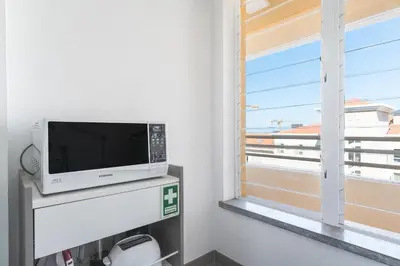 a flat screen tv sitting on a shelf next to a window at Sunny Stay Green Park by Atlantic Holiday in Panasqueira