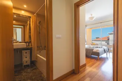a bedroom with a bed and a bathroom with a mirror at Sunny Stay Green Park by Atlantic Holiday in Panasqueira