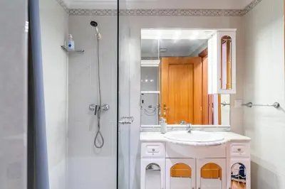 a bathroom with a sink and a shower with a mirror at GuestReady – Scenic Stay in the Heart of Funchal in Funchal