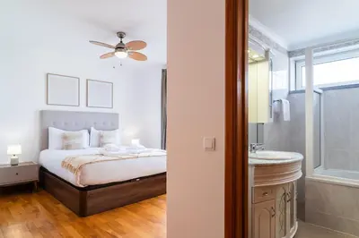 a bedroom with a bed and a sink and a mirror at GuestReady – Scenic Stay in the Heart of Funchal in Funchal