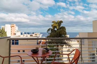 a balcony with a table and chairs and the ocean at GuestReady – Scenic Stay in the Heart of Funchal in Funchal