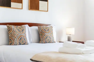 a bedroom with a white bed with pillows and a lamp at GuestReady – Scenic Stay in the Heart of Funchal in Funchal