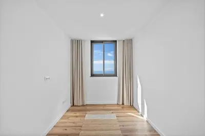 an empty corridor with a door and a window at Atlantis Apartment in Câmara de Lobos