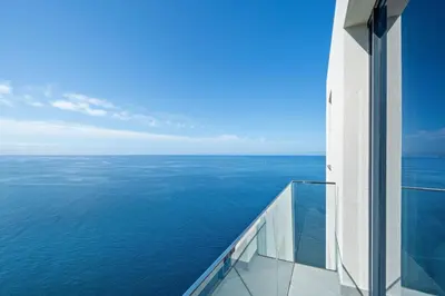 a view of the ocean from the balcony of a building at Atlantis Apartment in Câmara de Lobos