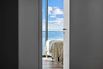 a door leading to a bedroom with a view of the ocean at Atlantis Apartment in Câmara de Lobos