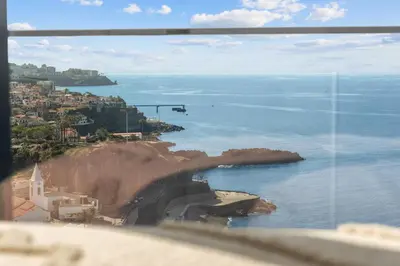a view of the ocean from a window at Atlantis Apartment in Câmara de Lobos