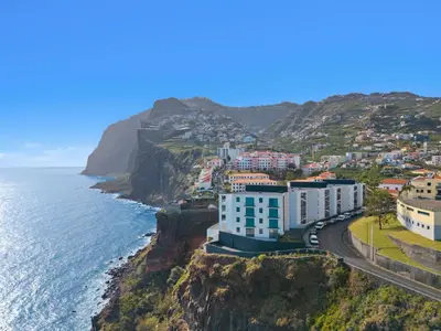 a city on a cliff next to the ocean at Atlantis Apartment in Câmara de Lobos