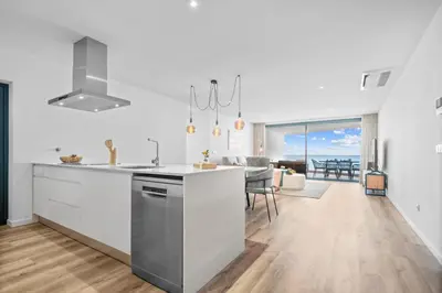 a kitchen and living room with a view of the ocean at Atlantis Apartment in Câmara de Lobos