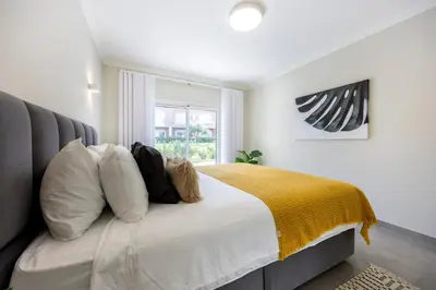 a bedroom with a large bed with a yellow blanket at Boa Vista - Salo Apartment in Lagos