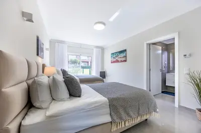 a white bedroom with a large bed with pillows at Boa Vista - Salo Apartment in Lagos