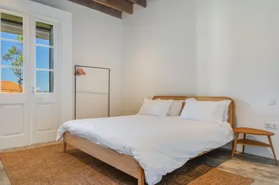 a bedroom with a bed with white sheets and a window at Luxury Quinta Rosa by Holiday Rental Madeira in Funchal